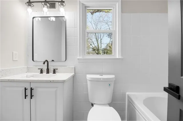 a bathroom with a toilet sink and mirror