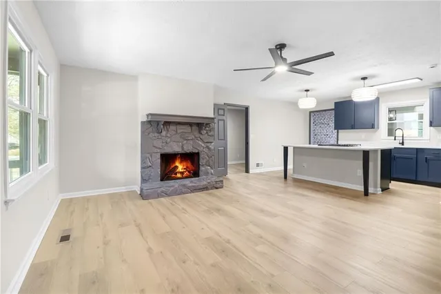 a view of an empty room with a fireplace and a window