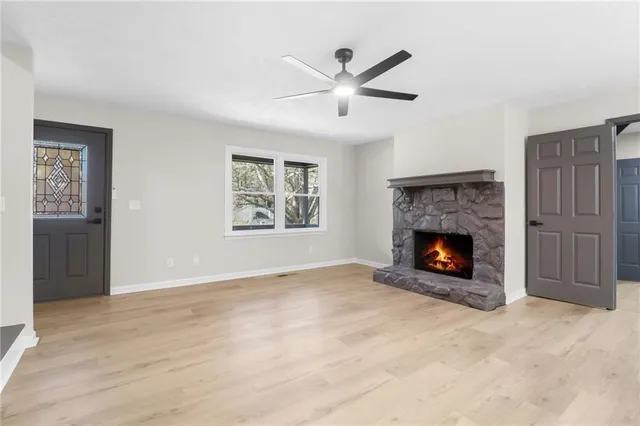 an empty room with windows and fireplace