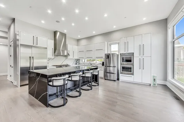 a kitchen with stainless steel appliances a refrigerator a sink dishwasher and a stove top oven