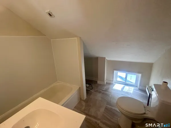 a bathroom with a sink toilet mirror and bathtub