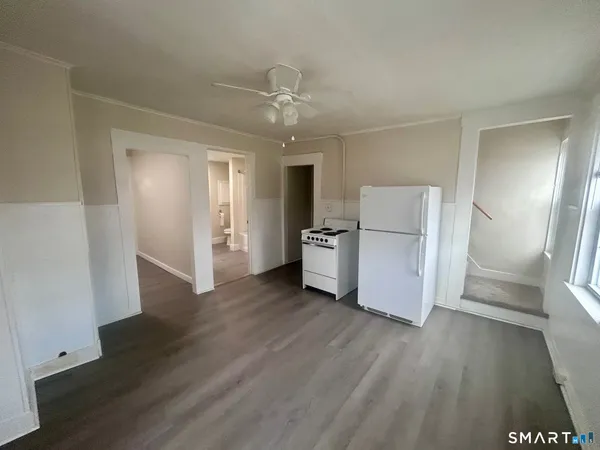 a view of a kitchen with a refrigerator a ceiling fan and wooden floor