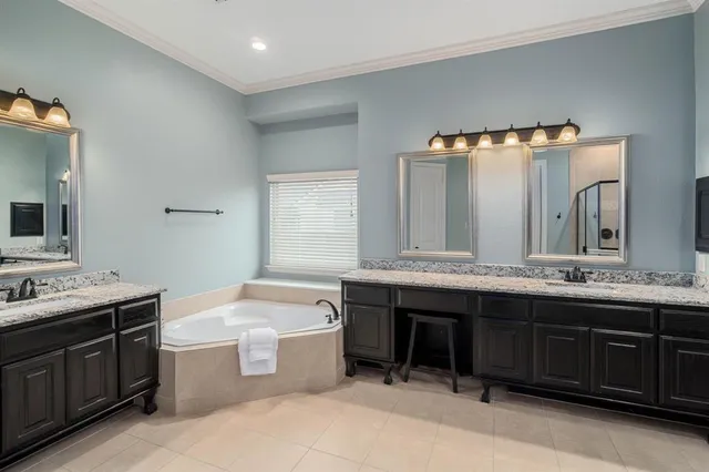 a bathroom with a granite countertop bathtub sink vanity and mirror