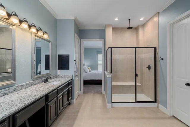 a bathroom with a granite countertop sink a mirror and a shower