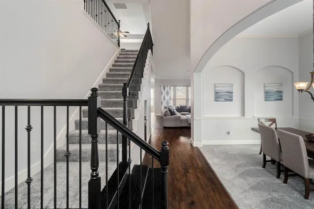 a view of a hallway with wooden floor and stairs