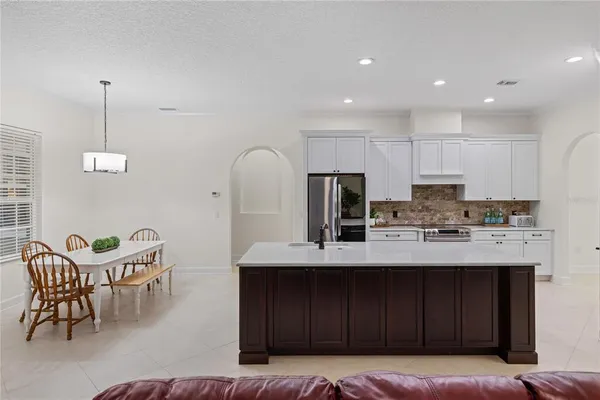 a kitchen with kitchen island granite countertop a sink and a refrigerator