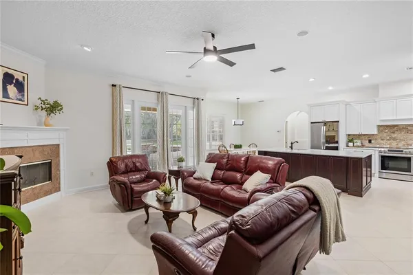 a living room with furniture ceiling fan and a fireplace