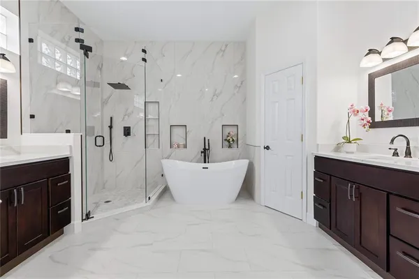 a bathroom with a double vanity sink mirror bathtub and shower