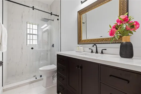 a bathroom with a sink vanity mirror and toilet