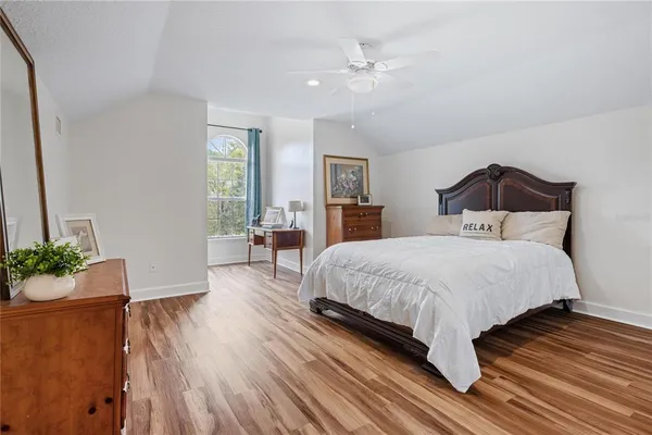 a spacious bedroom with a bed and a potted plant