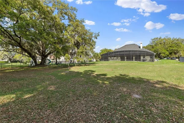 a view of yard with swimming pool and green space