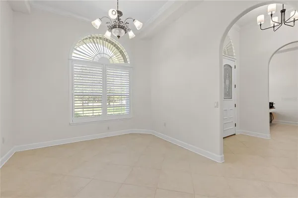 an empty room with a chandelier and a window
