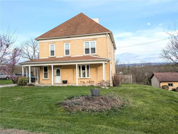 a front view of a house with a yard and trees