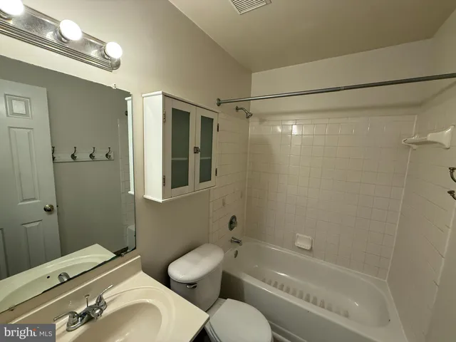 a bathroom with a sink mirror toilet and shower