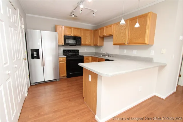 a kitchen with a sink a microwave a refrigerator and cabinets
