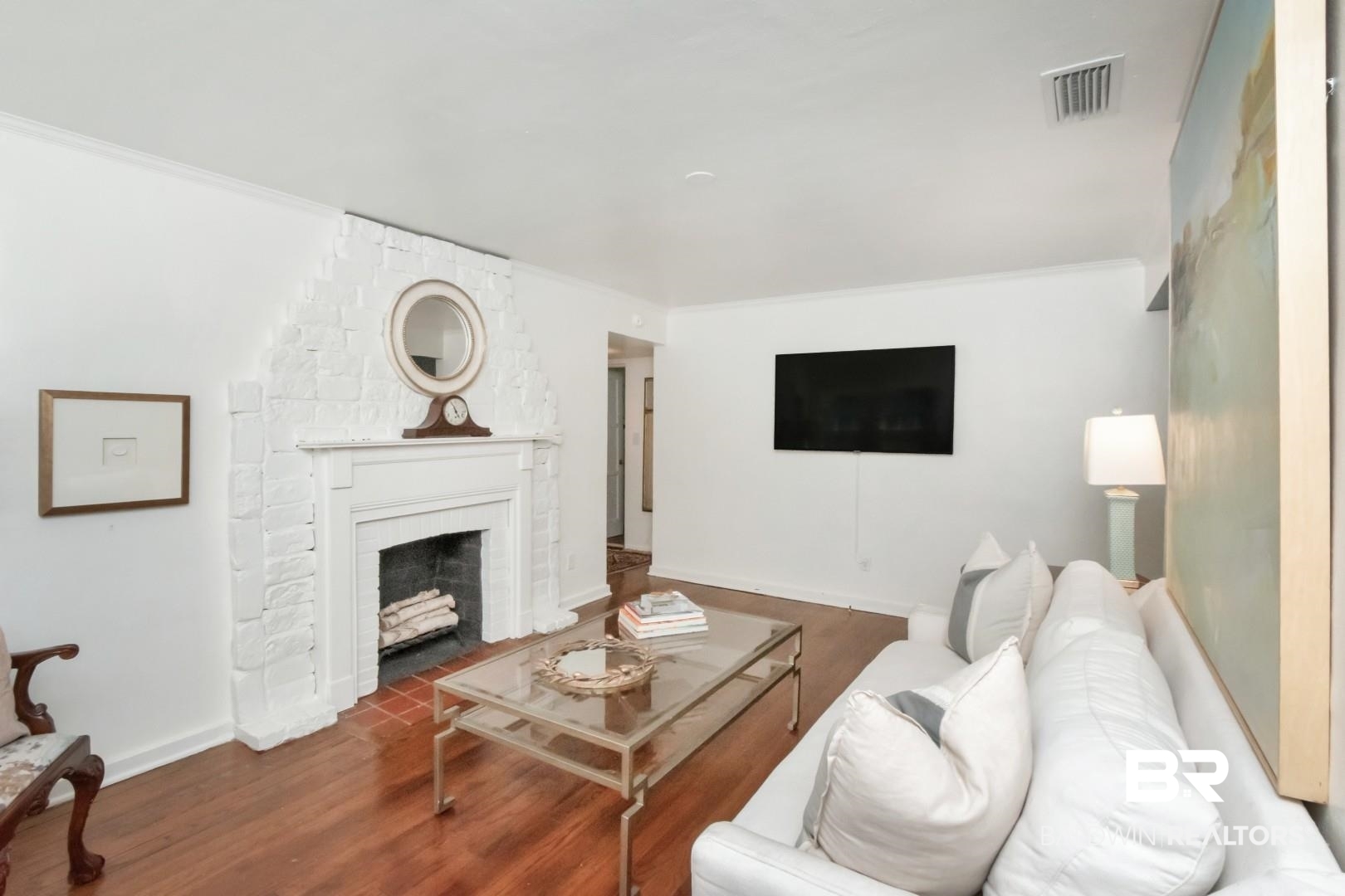 18 Princess Anne Road Mobile, AL 36608 - Photo 5 of 41 Living room featuring wood finished floors, ornamental molding, and a brick fireplace