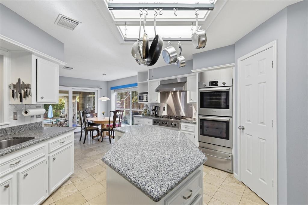 7608 Tallow Road Irving, TX 75063 - Photo 11 of 40 a kitchen with stainless steel appliances granite countertop a sink a stove oven and cabinets
