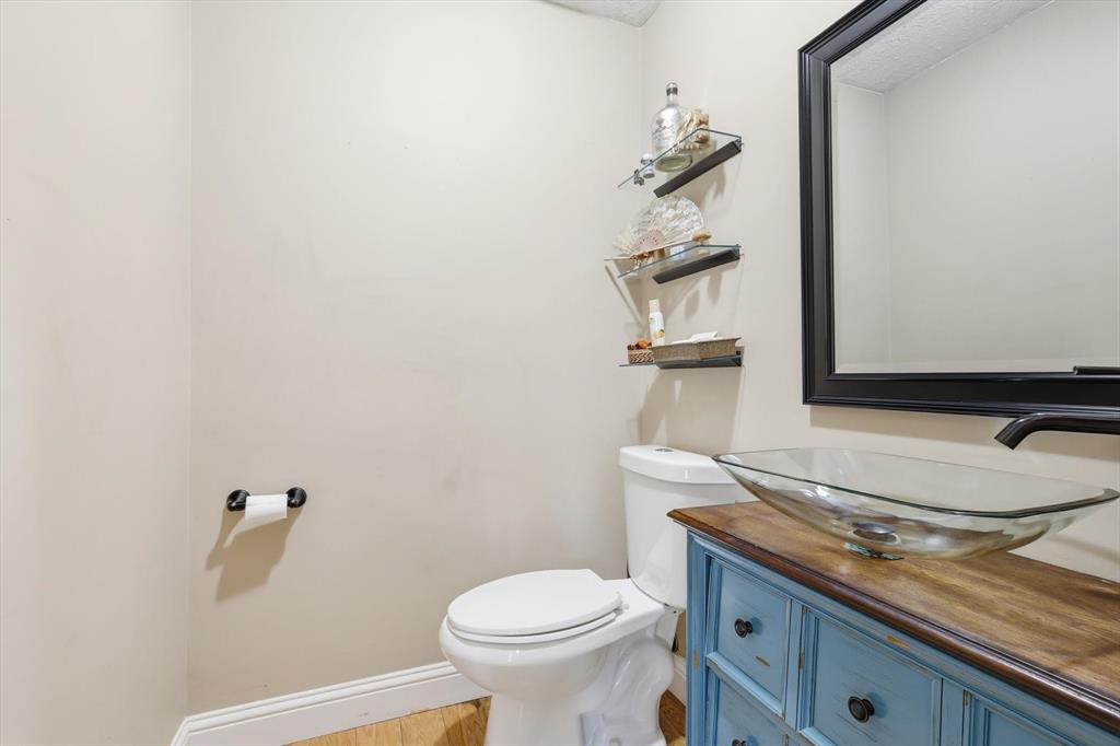 7608 Tallow Road Irving, TX 75063 - Photo 18 of 40 a bathroom with a granite countertop toilet and a sink
