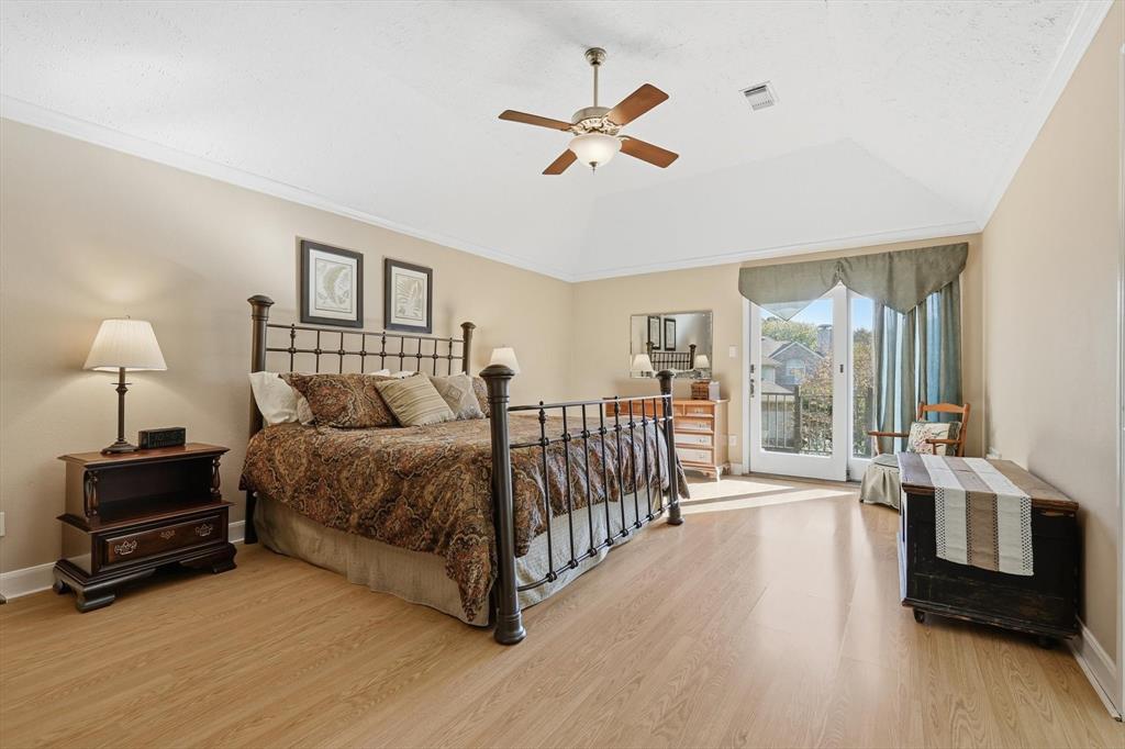 7608 Tallow Road Irving, TX 75063 - Photo 19 of 40 a spacious bedroom with a bed a chandelier and a large window