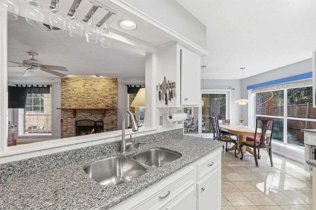 7608 Tallow Road Irving, TX 75063 - Photo 10 of 40 a kitchen with a sink stainless steel appliances a dining table and chairs