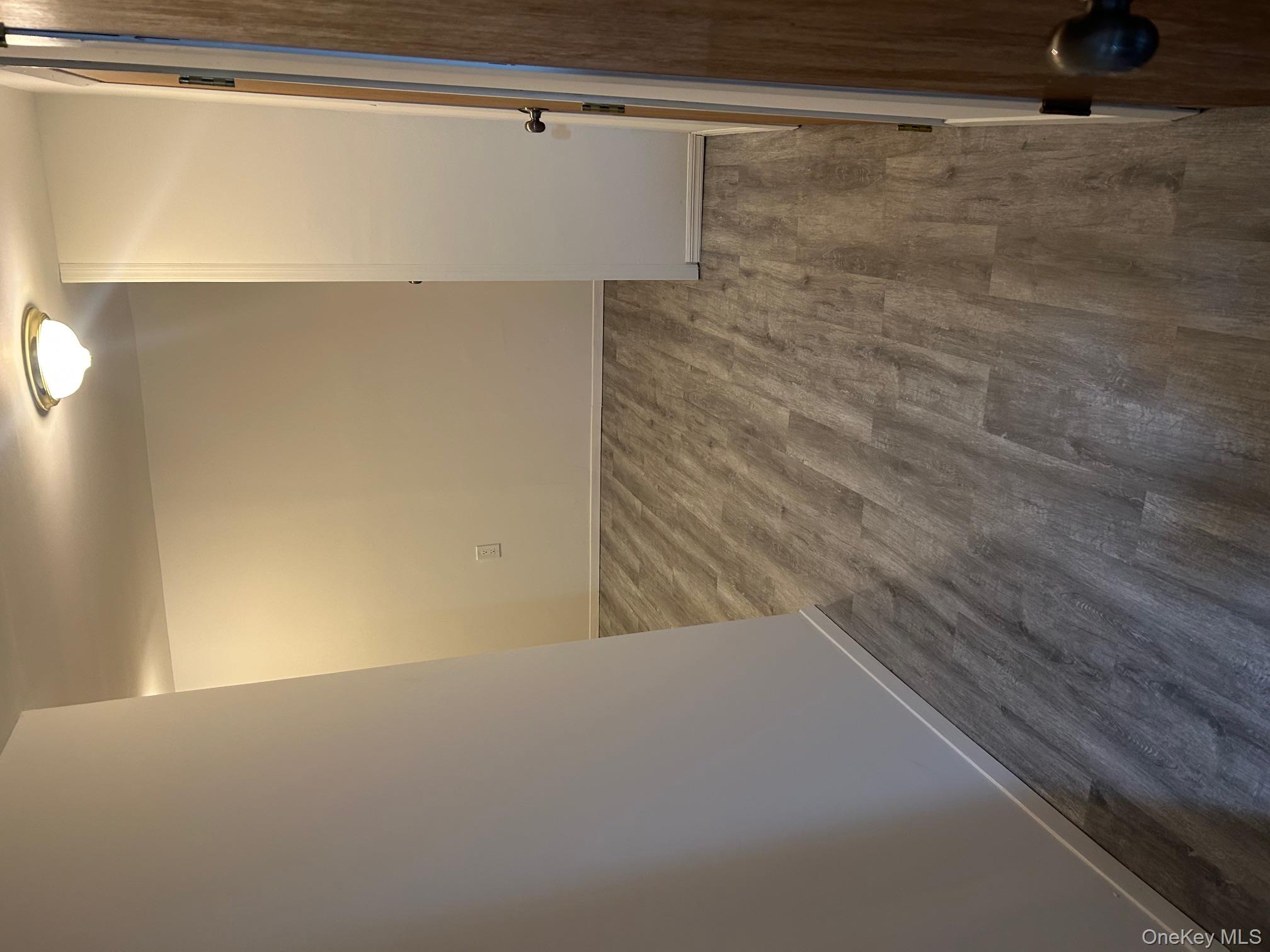 676 Front Street, Unit F Hempstead, NY 11550 - Photo 15 of 19 Empty room featuring baseboards and dark wood-style floors