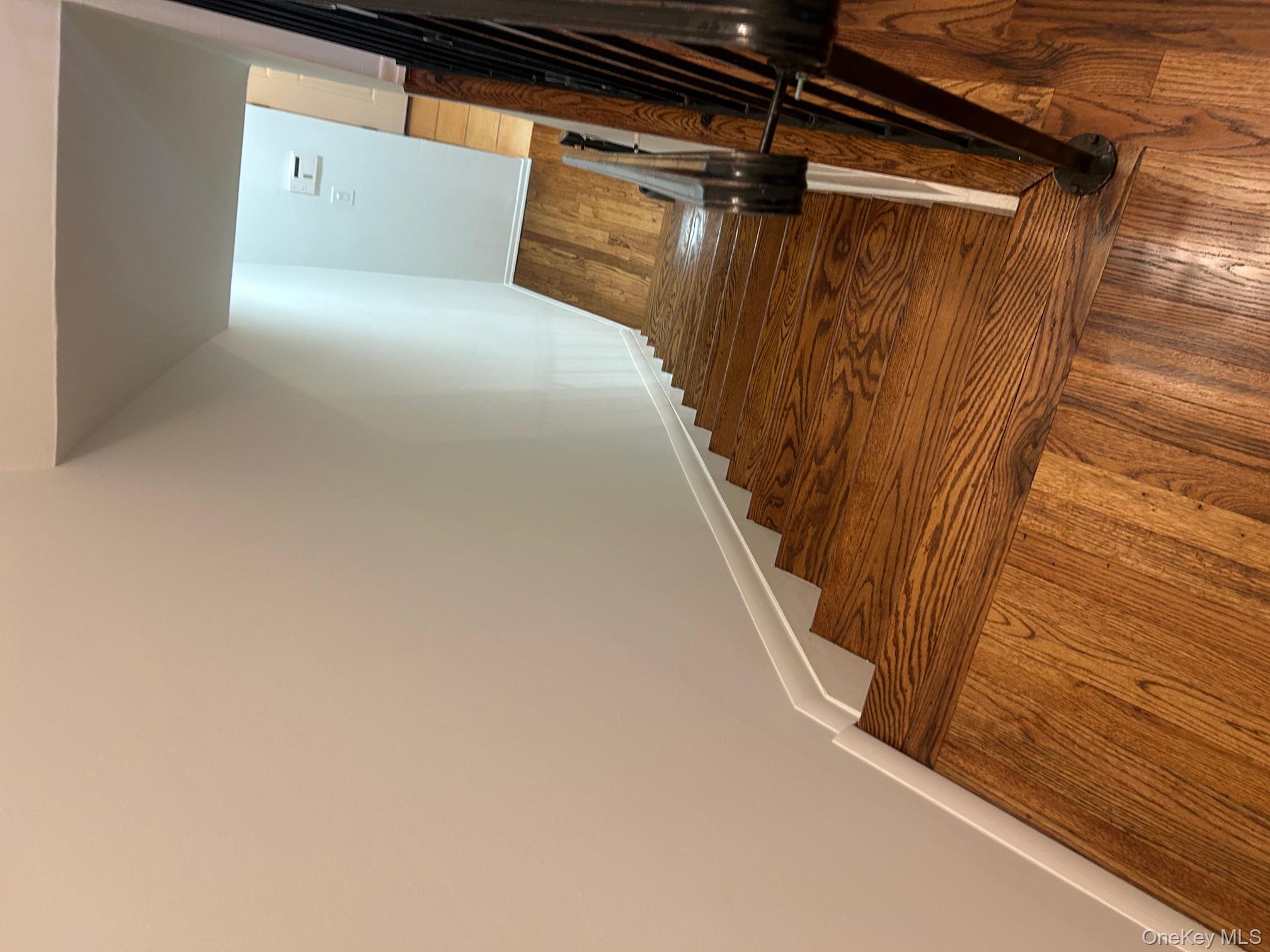 676 Front Street, Unit F Hempstead, NY 11550 - Photo 17 of 19 Stairs with baseboards and hardwood / wood-style floors