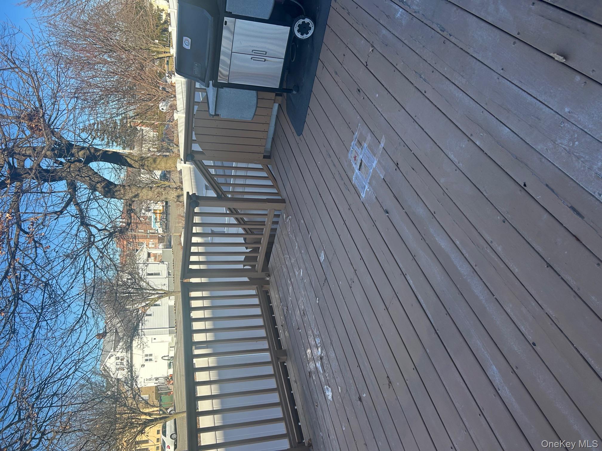 676 Front Street, Unit F Hempstead, NY 11550 - Photo 18 of 19 Wooden terrace with grilling area and a residential view