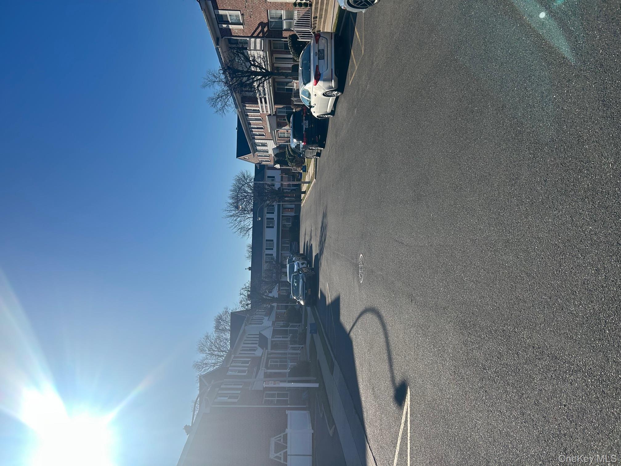 676 Front Street, Unit F Hempstead, NY 11550 - Photo 3 of 19 View of asphalt road featuring a residential view, sidewalks, and curbs