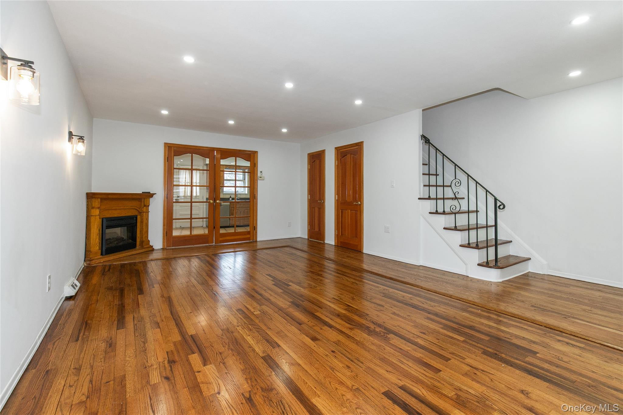 676 Front Street, Unit F Hempstead, NY 11550 - Photo 5 of 18 a view of an empty room with wooden floor and fireplace