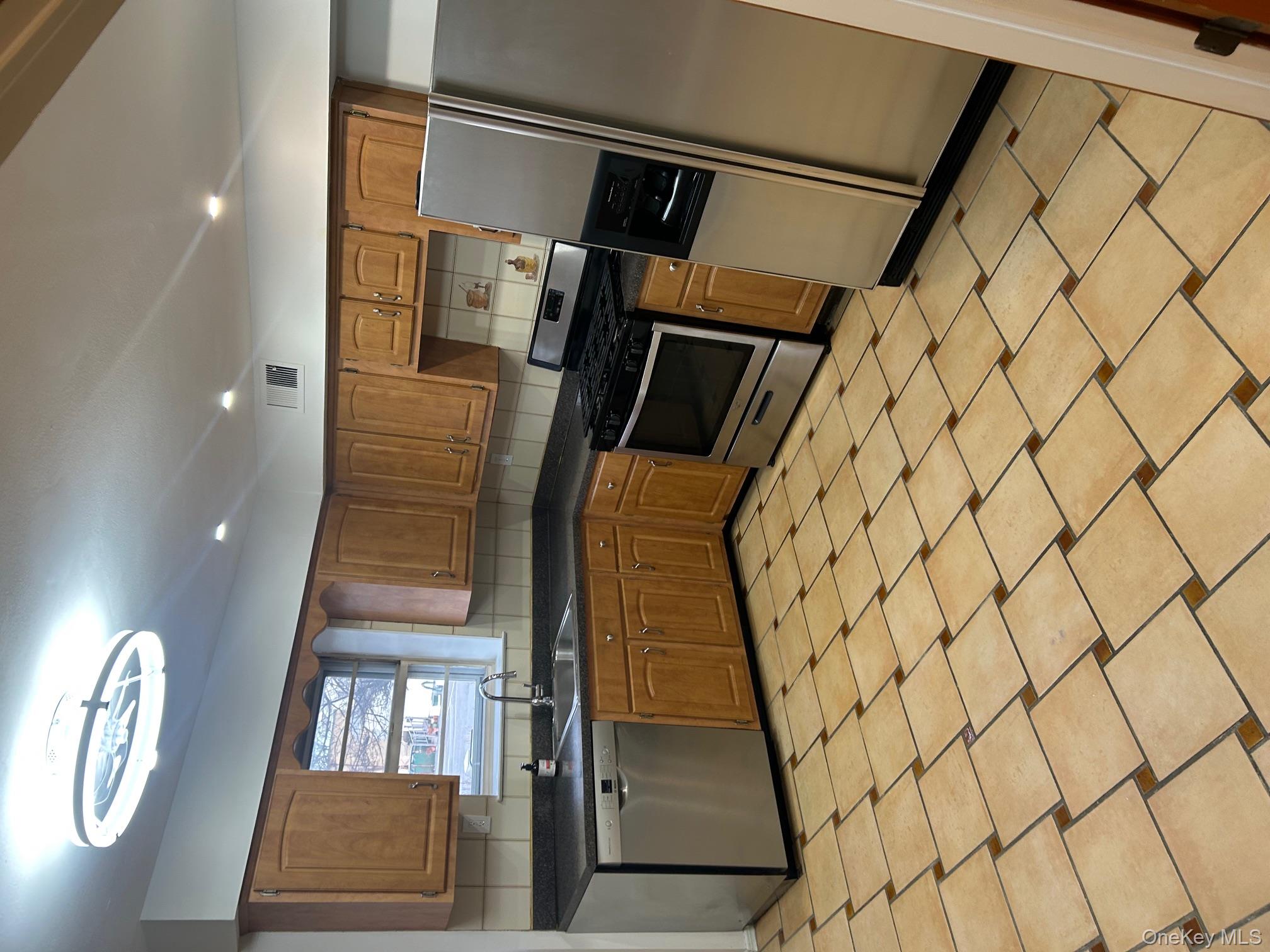 676 Front Street, Unit F Hempstead, NY 11550 - Photo 6 of 19 Kitchen featuring fridge, brown cabinets, stainless steel stove, and recessed lighting
