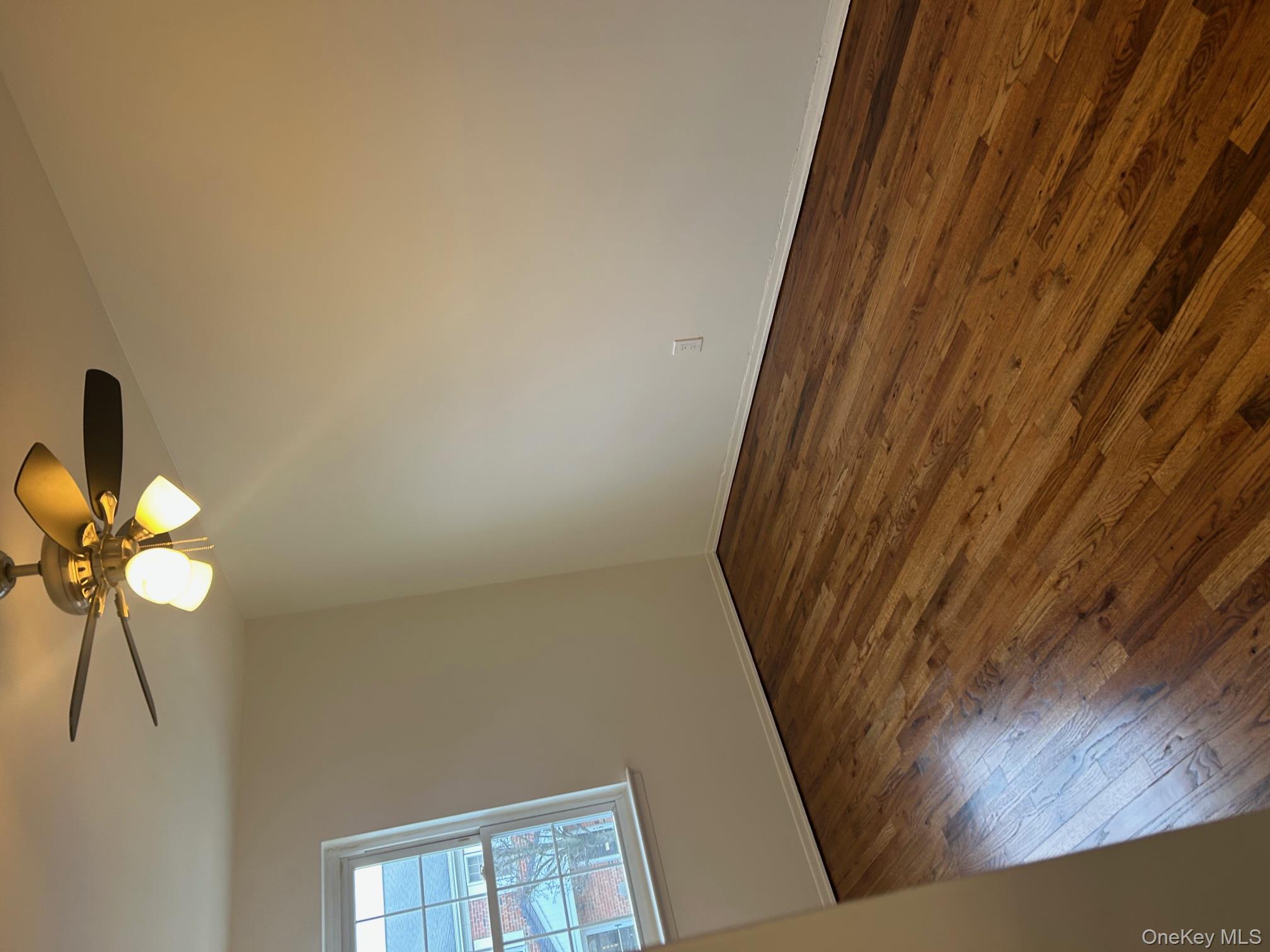 676 Front Street, Unit F Hempstead, NY 11550 - Photo 8 of 19 Empty room with dark wood-style flooring and a ceiling fan