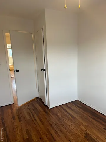 an empty room with wooden floor and window