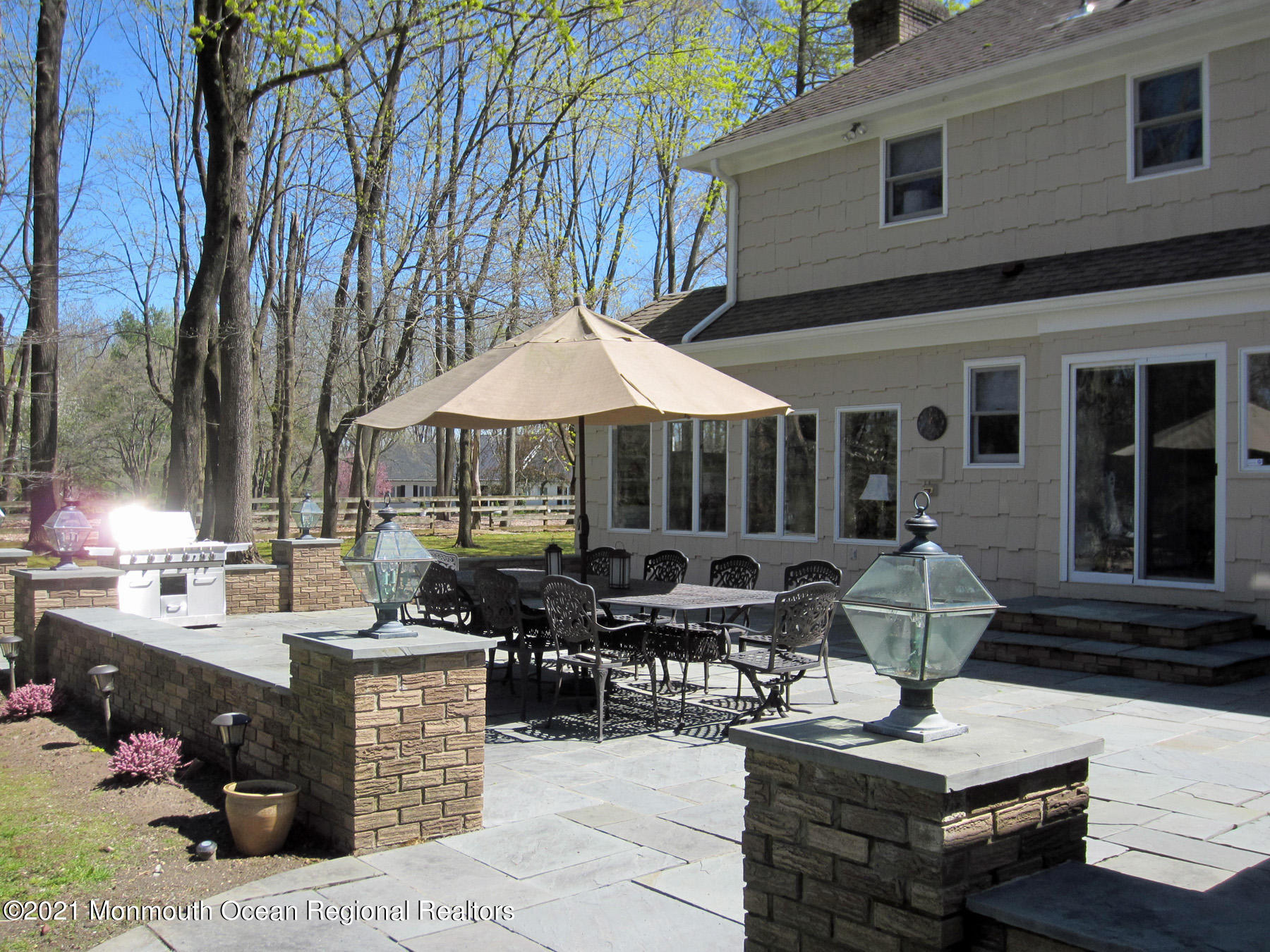 24 Beaver Dam Road Colts Neck, NJ 07722 - Photo 22 of 31 a view of a patio with couches table and chairs under an umbrella with a barbeque