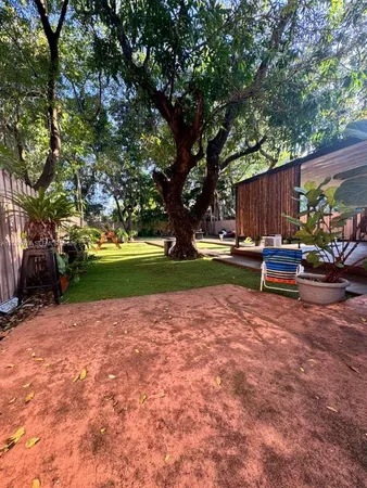 a patio with table and chairs a fire pit and a large tree