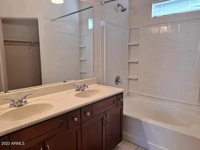 a bathroom with a sink double vanity granite tub shower and a mirror