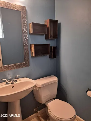 a bathroom with a toilet a sink and mirror