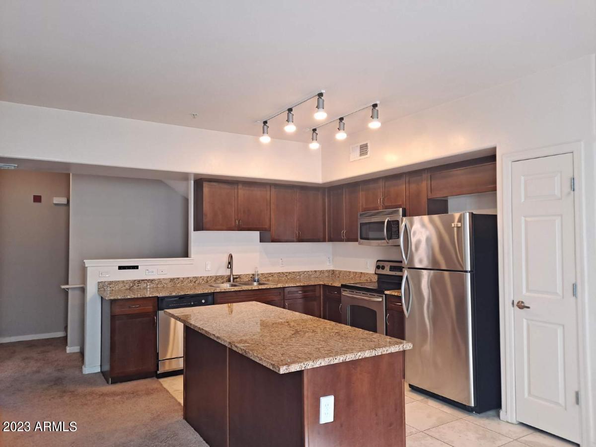 1920 East Bell Road, Unit 1114 Phoenix, AZ 85022 - Photo 4 of 18 a kitchen with a sink a refrigerator and a stove