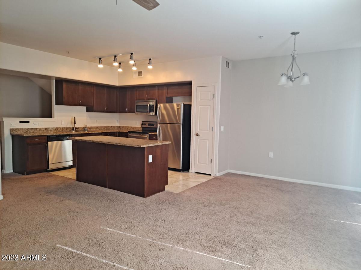 1920 East Bell Road, Unit 1114 Phoenix, AZ 85022 - Photo 6 of 18 a kitchen with kitchen island a sink stainless steel appliances and cabinets