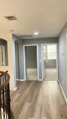 a view of a hallway with wooden floor and staircase