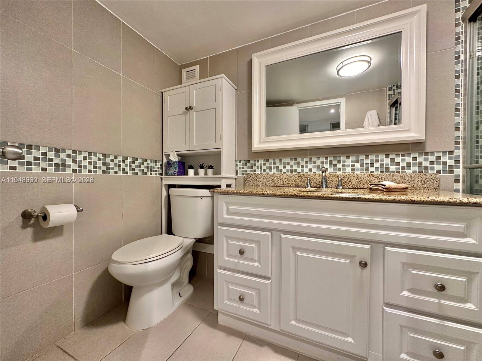 17011 North Bay Road, Unit 202 Sunny Isles Beach, FL 33160 - Photo 18 of 32 a bathroom with a toilet sink and mirror