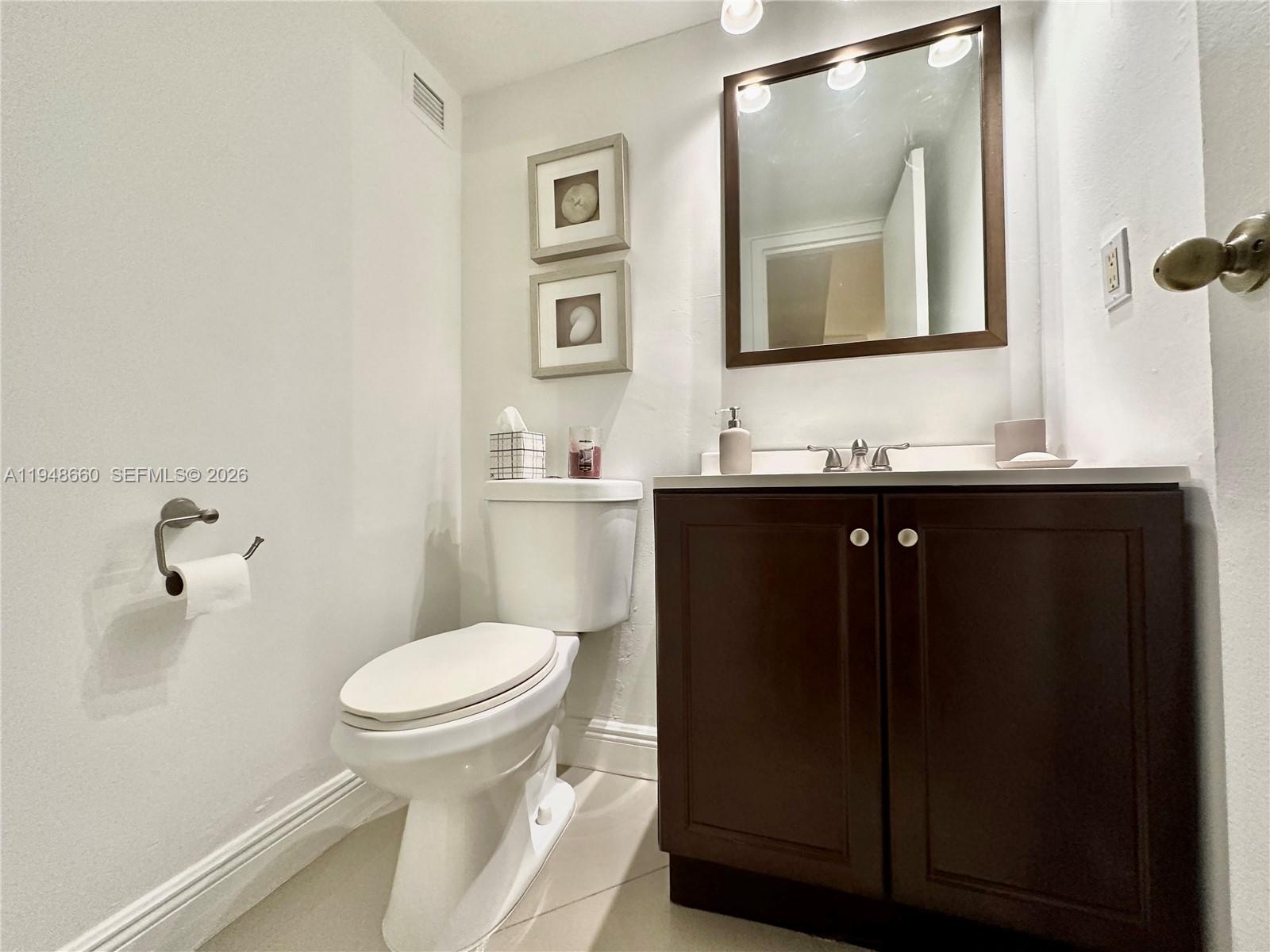 17011 North Bay Road, Unit 202 Sunny Isles Beach, FL 33160 - Photo 19 of 32 a bathroom with a toilet sink and mirror