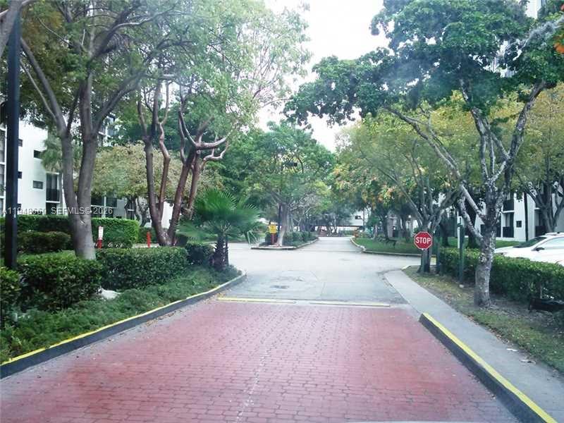 17011 North Bay Road, Unit 202 Sunny Isles Beach, FL 33160 - Photo 32 of 32 a view of a street with trees on both side of the road