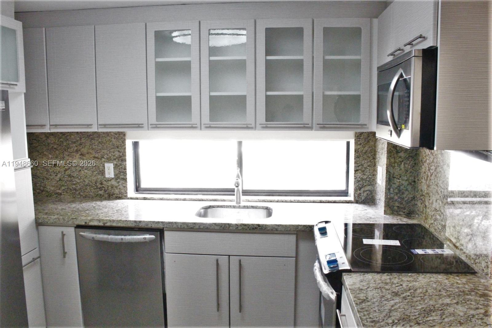 17011 North Bay Road, Unit 202 Sunny Isles Beach, FL 33160 - Photo 5 of 32 a kitchen with stainless steel appliances granite countertop a sink and a stove