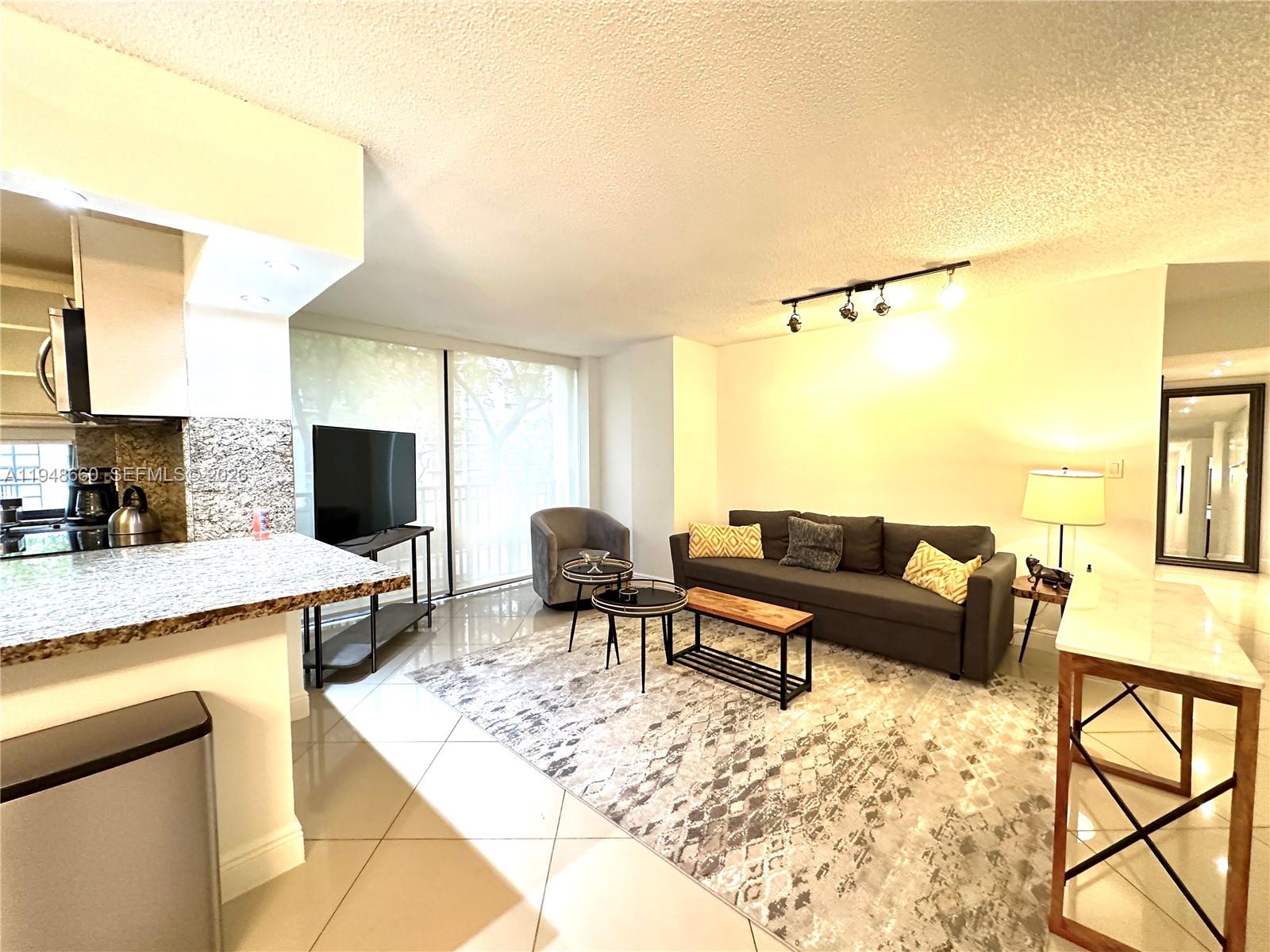 17011 North Bay Road, Unit 202 Sunny Isles Beach, FL 33160 - Photo 7 of 32 a living room with furniture and a flat screen tv