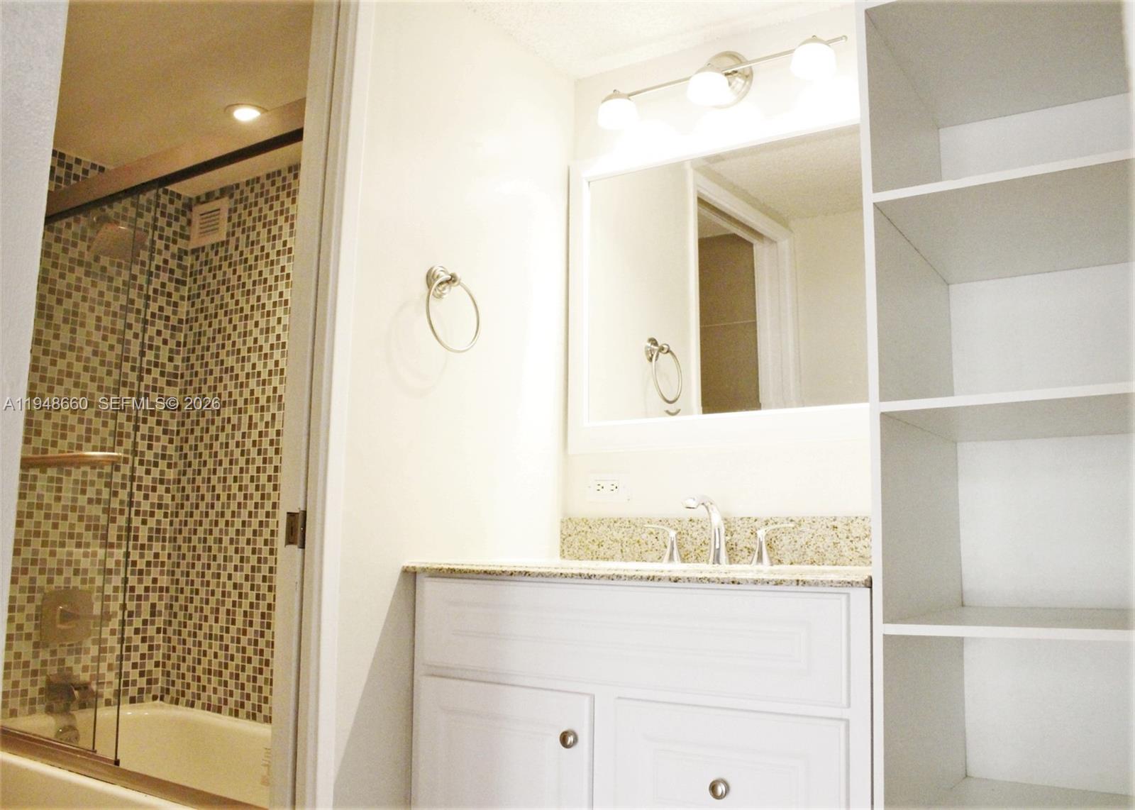 17011 North Bay Road, Unit 202 Sunny Isles Beach, FL 33160 - Photo 10 of 32 a bathroom with a granite countertop sink and a mirror