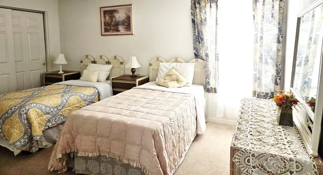 a bedroom with two beds and painting on the wall