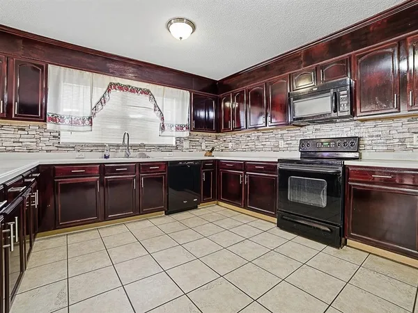 a kitchen with stainless steel appliances granite countertop a refrigerator and a stove