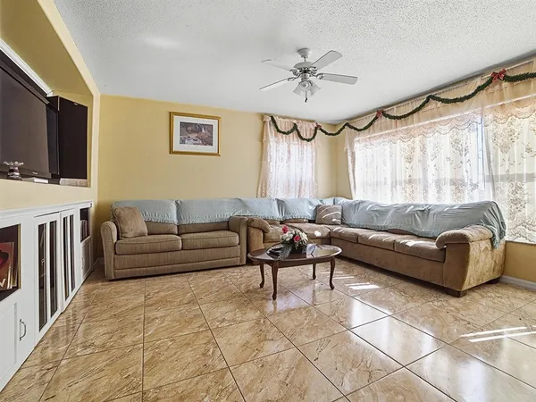 a living room with furniture a flat screen tv and a window