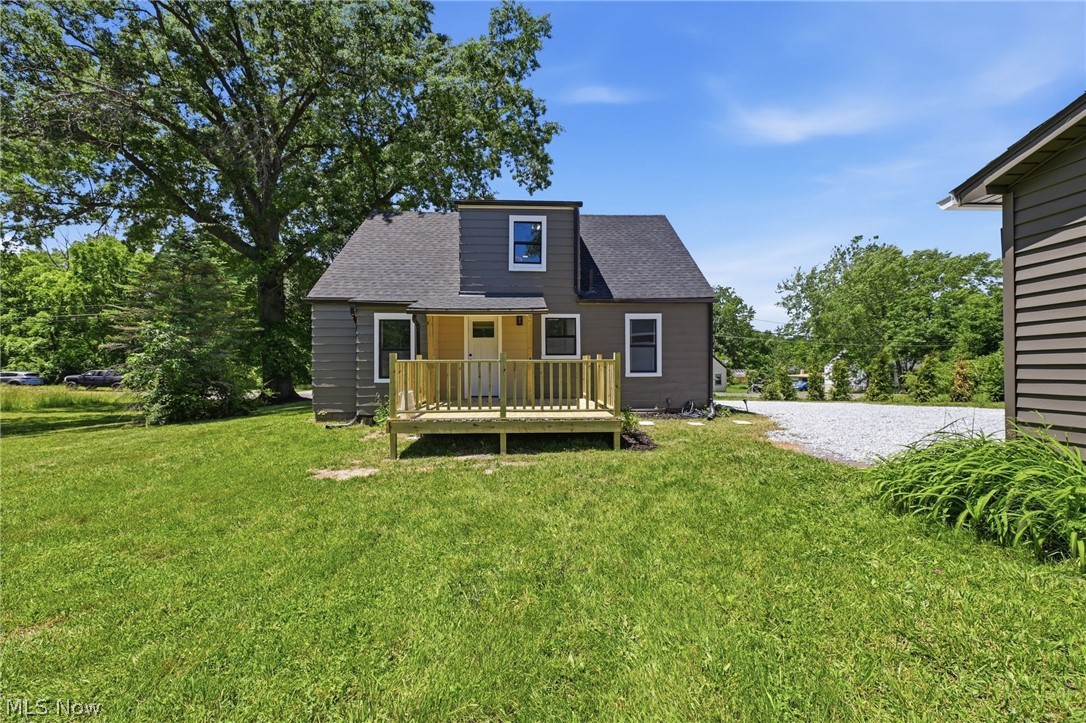 951 Bey Road Akron, OH 44312 - Photo 31 of 34 Charming residence featuring a dark gray exterior, white trim windows, a light wood-finish back deck with railing, and a dark shingle roof