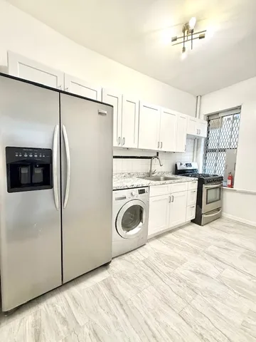 a kitchen with white cabinets and white appliances
